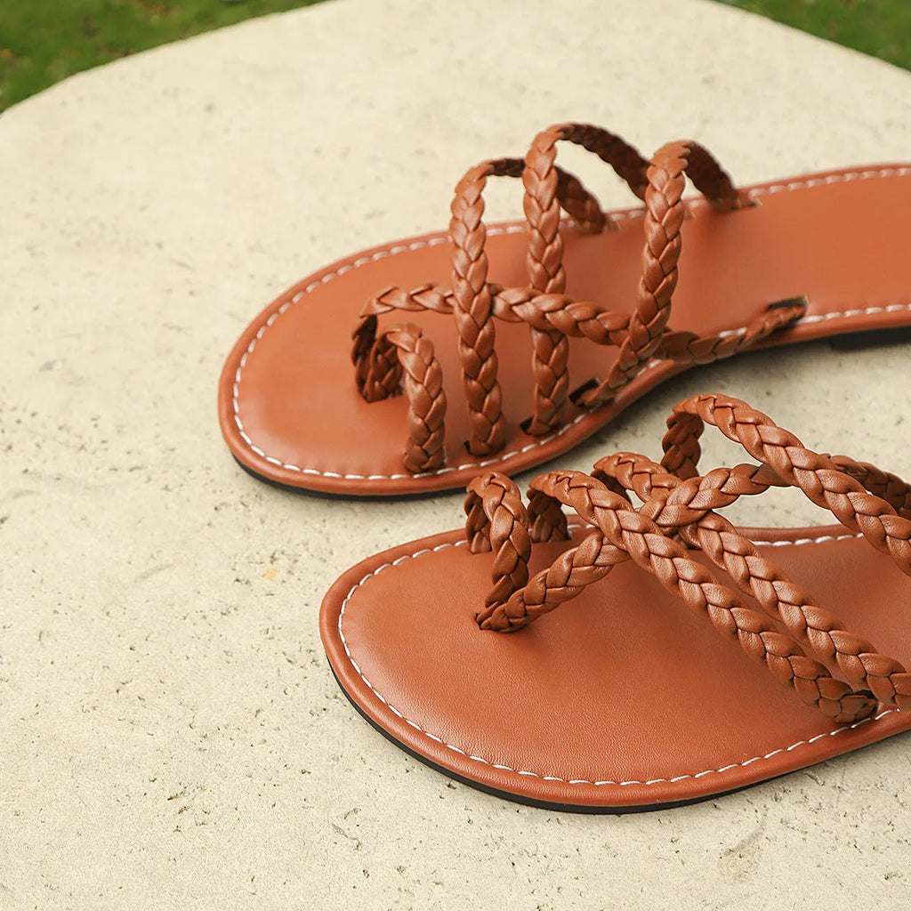 Women's black woven clip-toe flat sandals on a neutral background.