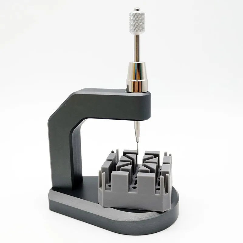 Silver tool steel multi-purpose press strap and pin removal tool on a work surface.