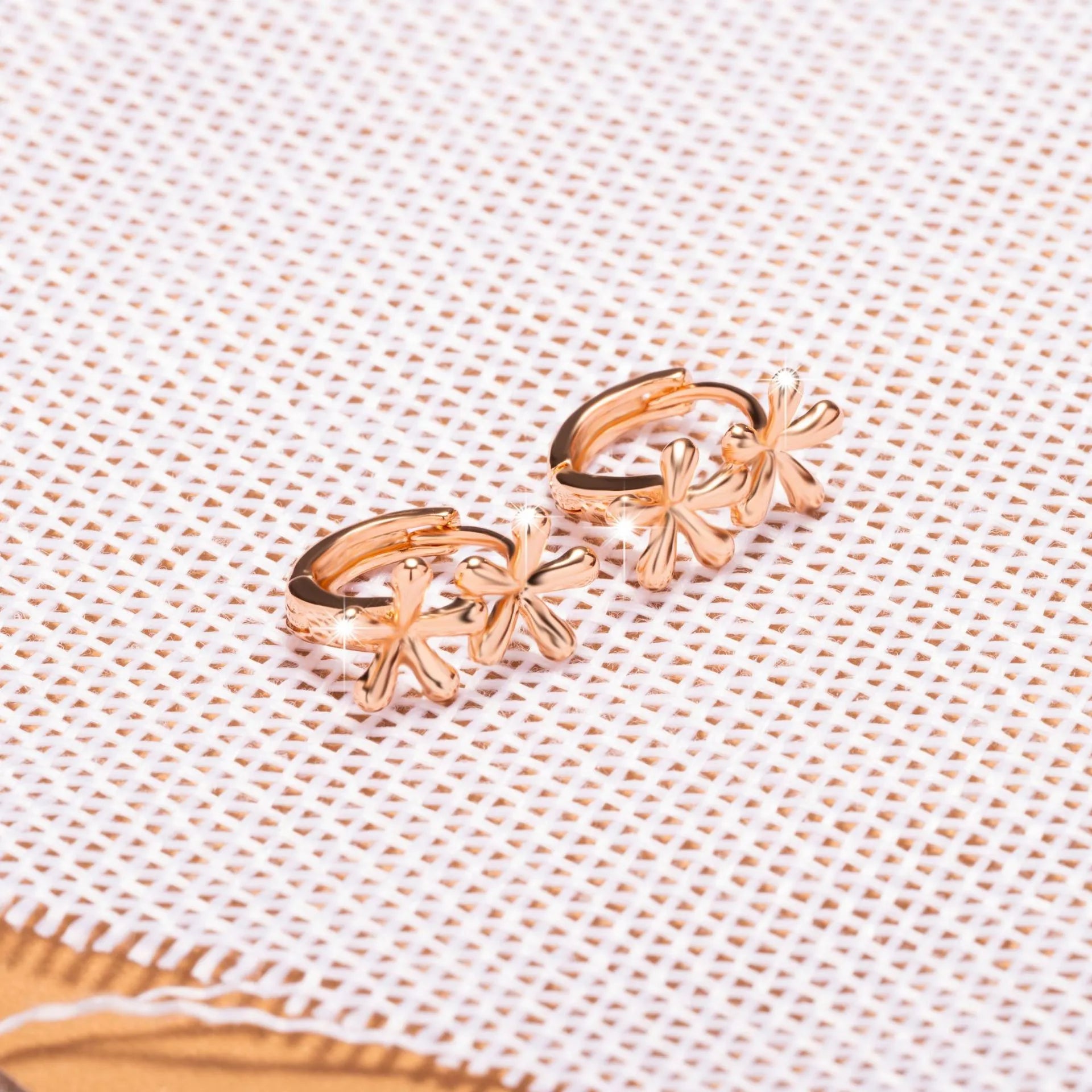 Rose gold circular earrings with a waterdrop flower design.