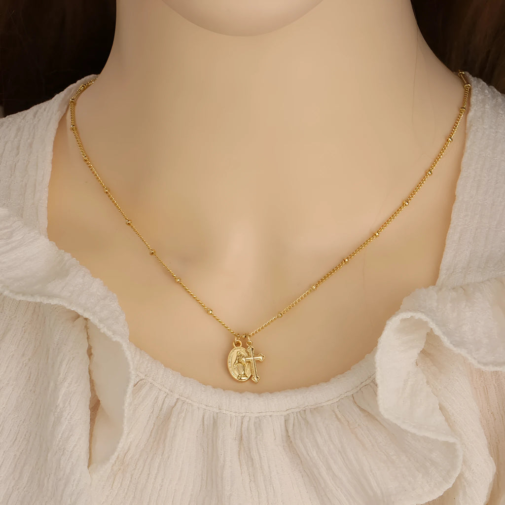 Gold geometric pendant necklace featuring the Virgin Mary on a chain.