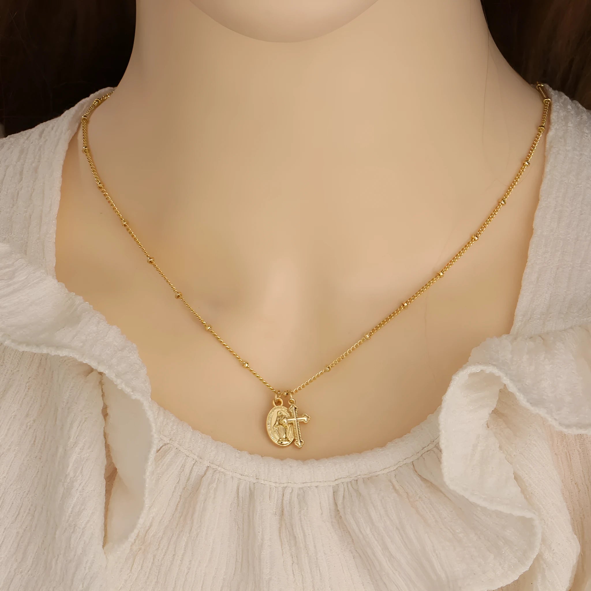 Gold geometric pendant necklace featuring the Virgin Mary on a chain.
