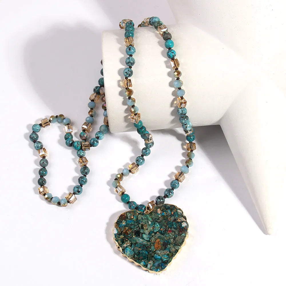 Bohemian style long chain heart pendant necklace in stone and glass with electroplated finish, available in multiple colours.