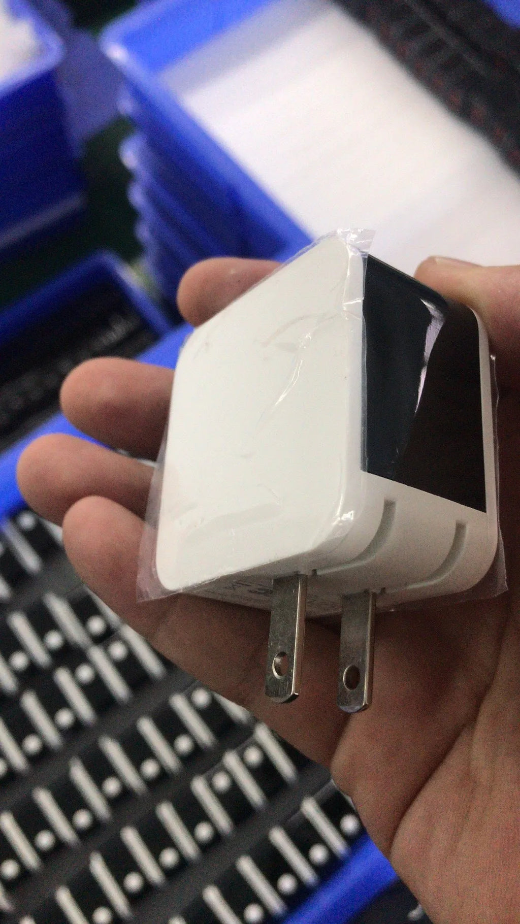 Black 5V 2.4A dual USB travel charger with digital display plugged into a wall socket.