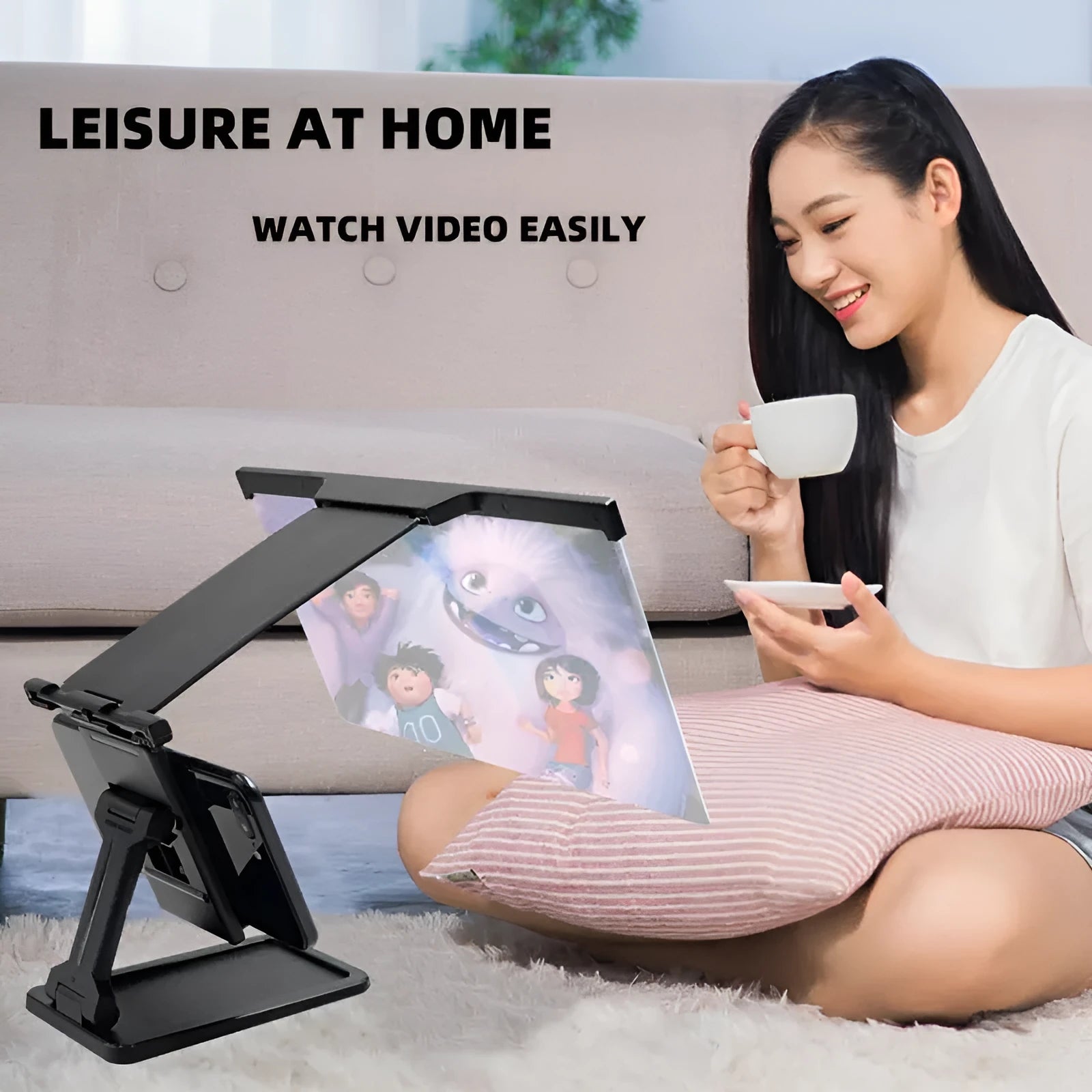 Black folding mobile phone screen magnifier and detachable holder on a desktop.