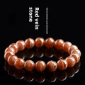 Natural old mine rhodochrosite round bead bracelet on wrist, showing geometric design and Ruyi symbol.