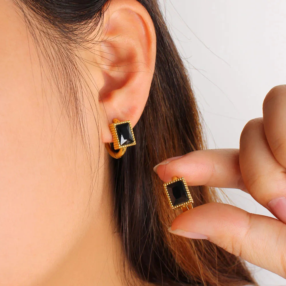 Square geometric stainless steel earrings with round rings and zircon accents, shown in white, black, and green colour options.