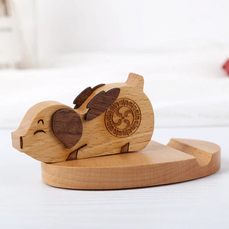 Custom lettering beech wood lazy phone holder with coin slot on a wooden table