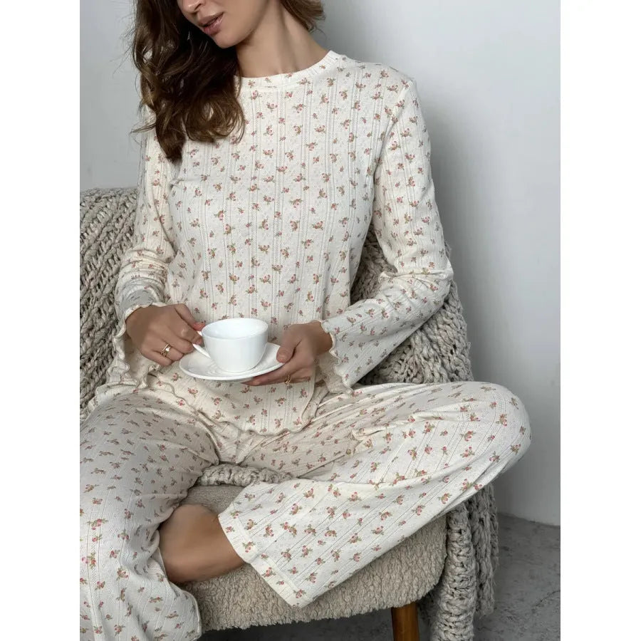 White women's floral print lounge suit with long bell sleeve top and wide leg trousers.