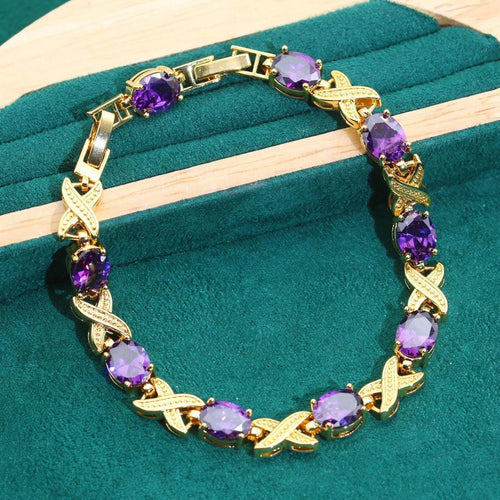 Gold plated jewellery set with coloured cubic zirconia stones showing necklace, earrings, ring, and bracelet.