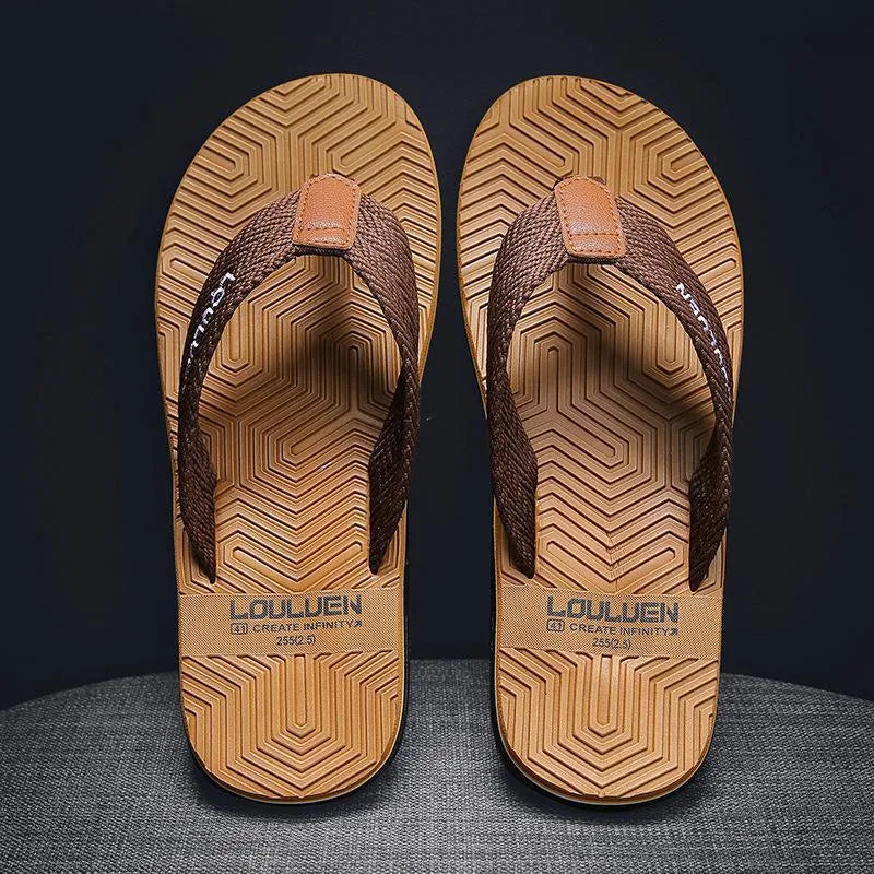 Men's black flip flops with textured non-slip PVC sole and EVA upper on a sandy beach.