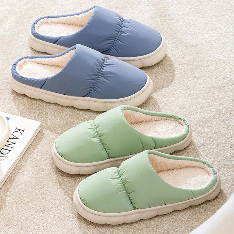 A pair of blue down cotton slippers with a thick sole, artificial leather upper, and plush lining for indoor winter wear.