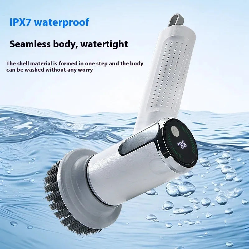 White cordless electric cleaning brush with interchangeable brush heads on a kitchen counter.
