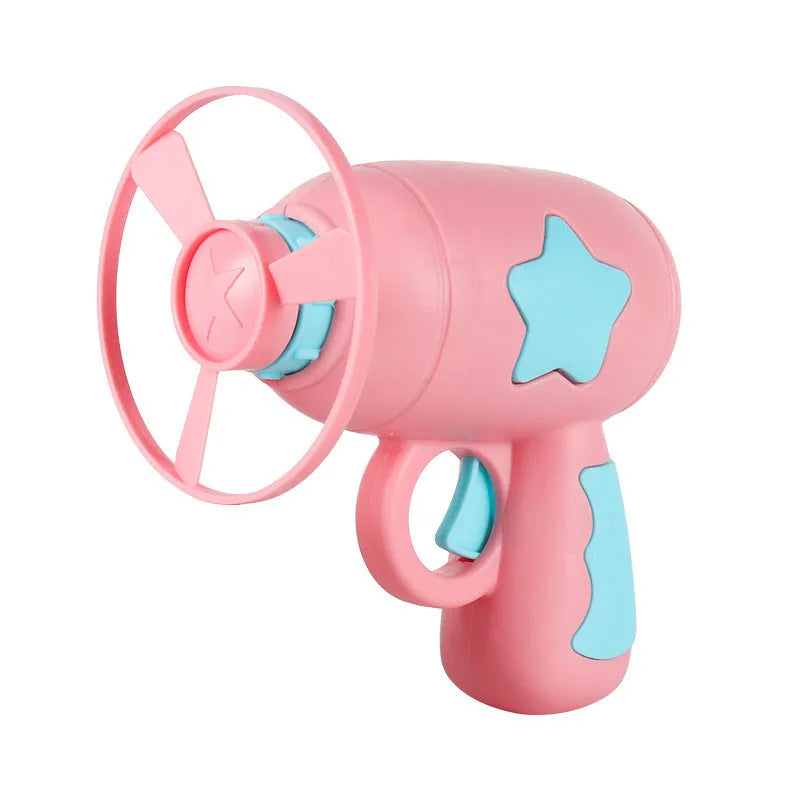 Plastic flying saucer launcher toy set with LED lights and coloured discs on outdoor grass.