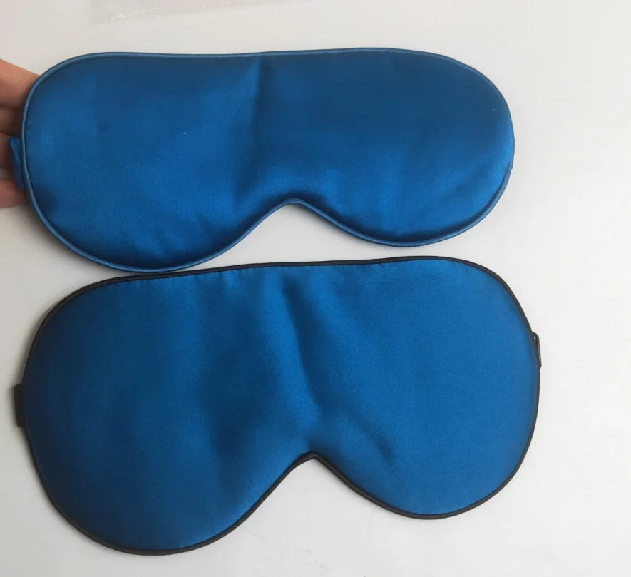 Silk double-sided eye mask in peacock blue and silver with adjustable strap, showing contoured nasal bridge design