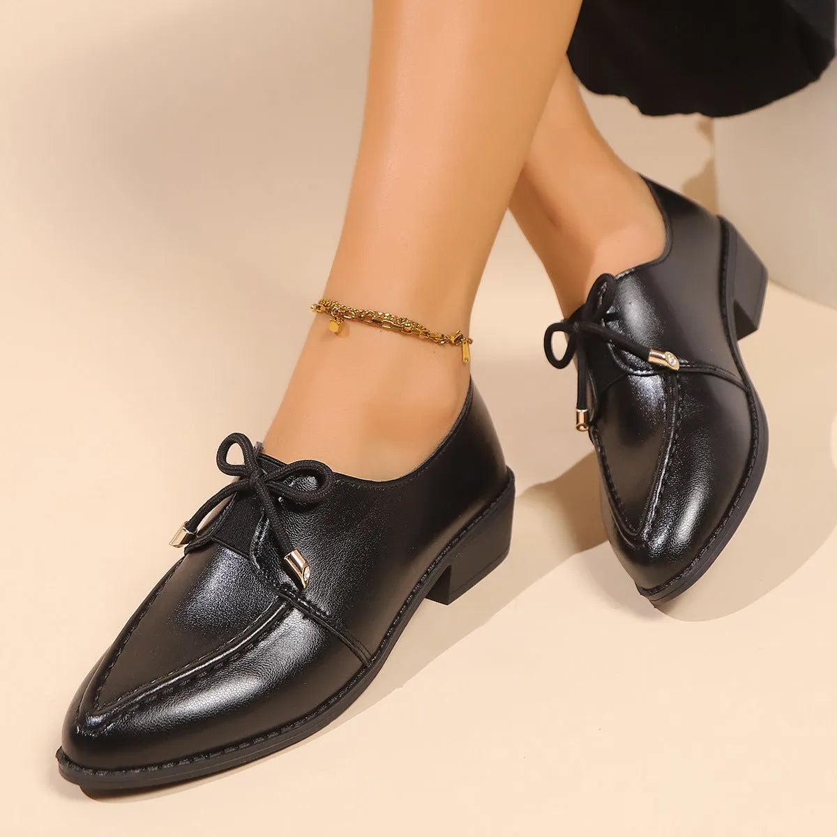 Women's pointed toe PU leather shoes with a bow detail on the upper.