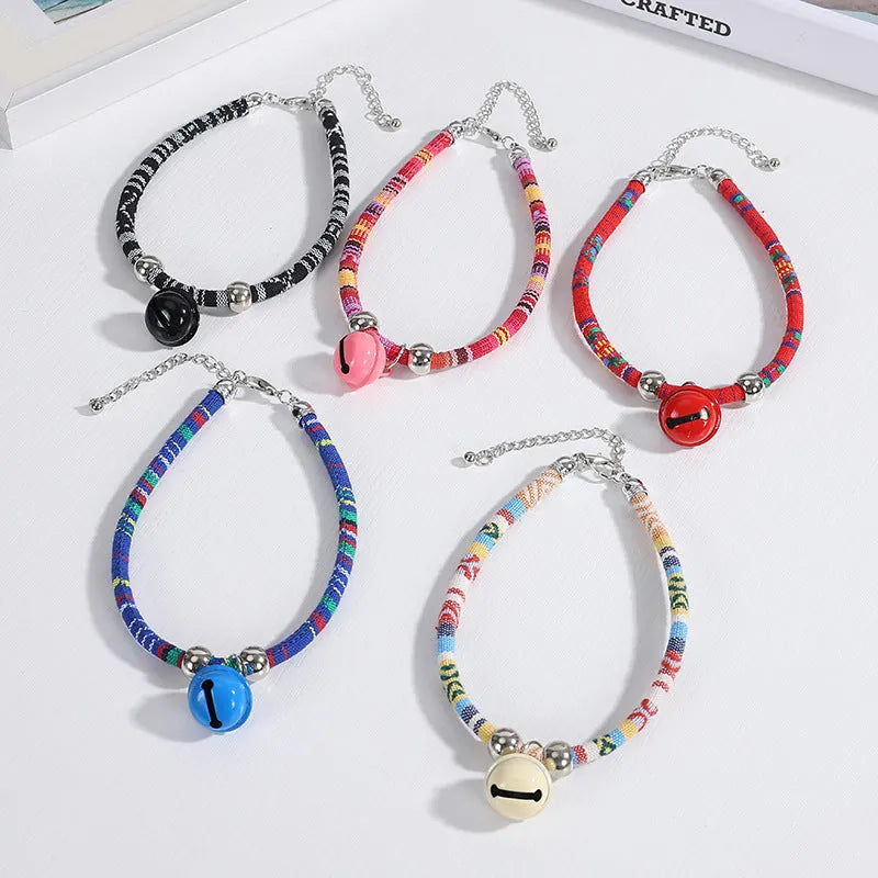 Ethnic pattern adjustable pet collar with bell attachment shown in multiple colour options