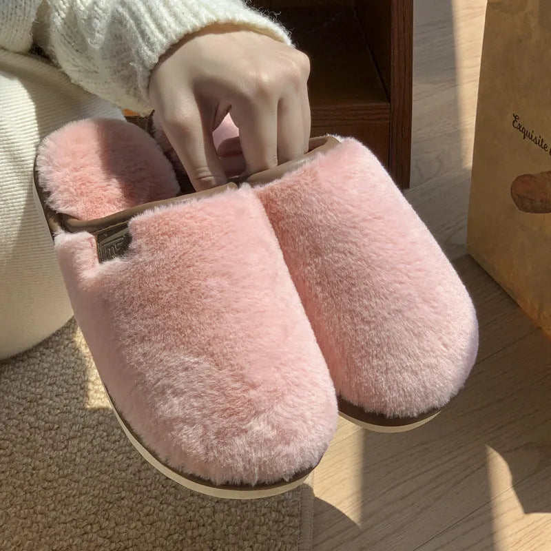 Blue plush slipper with non-slip PVC sole and car-stitching detail on a wooden floor.