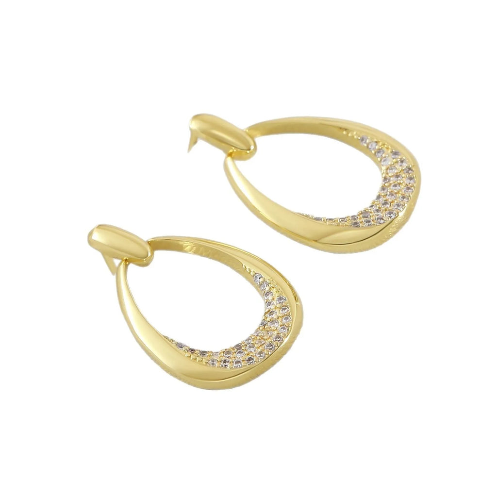 Yellow gold geometric drop-shaped women's earrings with round and oval ring elements on a simple background.