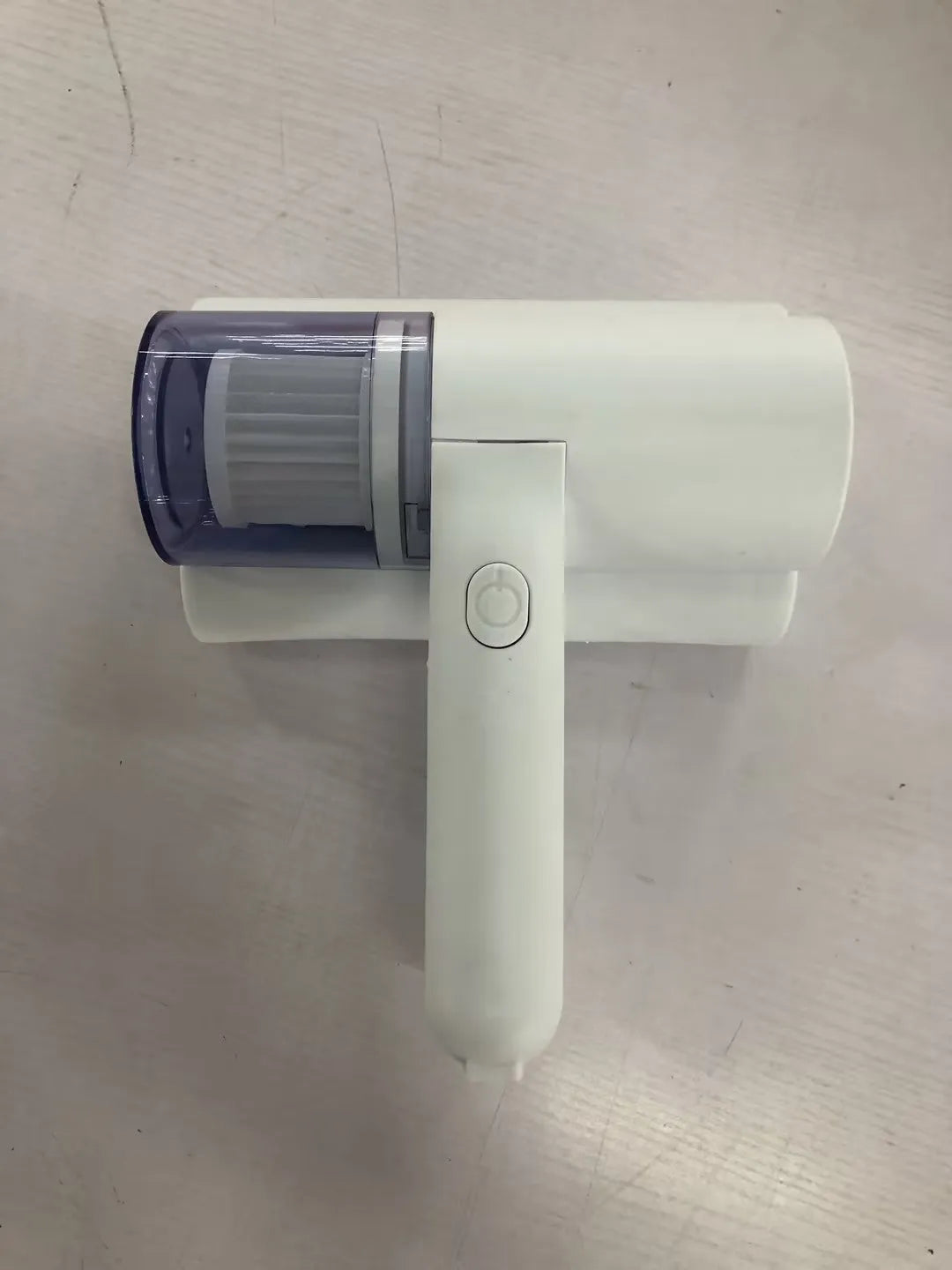 White wireless mite removal instrument with UV sterilization and 300W motor on a bed