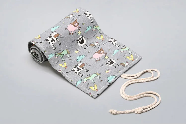 Canvas pencil wrap roll up case with multiple elastic bands holding pens and pencils, in a compact roll.
