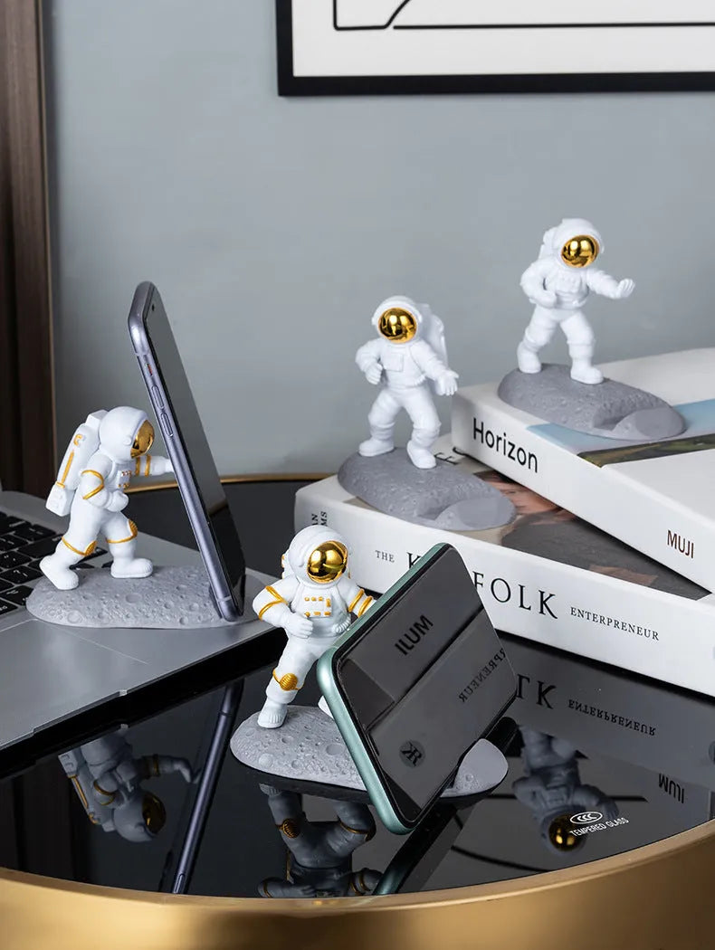 Plastic astronaut decoration mobile phone holder in blue colour on a desk