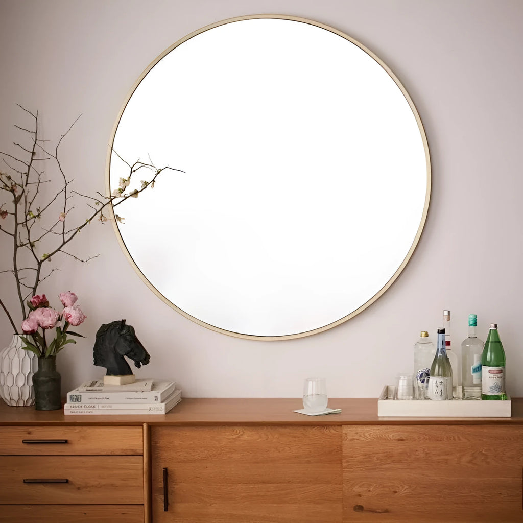 Round metal-framed wall mirror in black, white, or gold, shown in a bathroom setting.