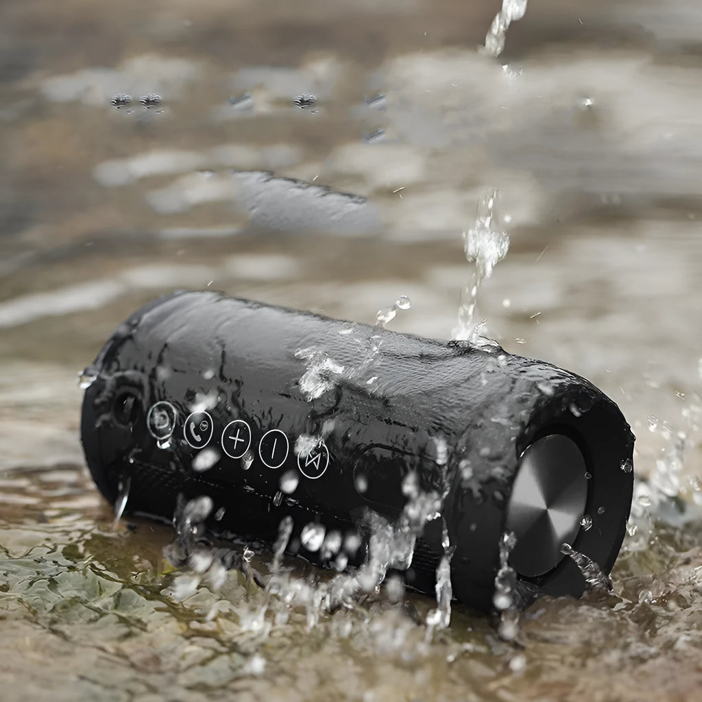 A portable waterproof outdoor Bluetooth speaker in black, shown with a mobile phone indicating wireless connectivity.