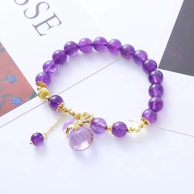 Purple amethyst bracelet with ethnic money bag pendant and peace buckle closure on wrist