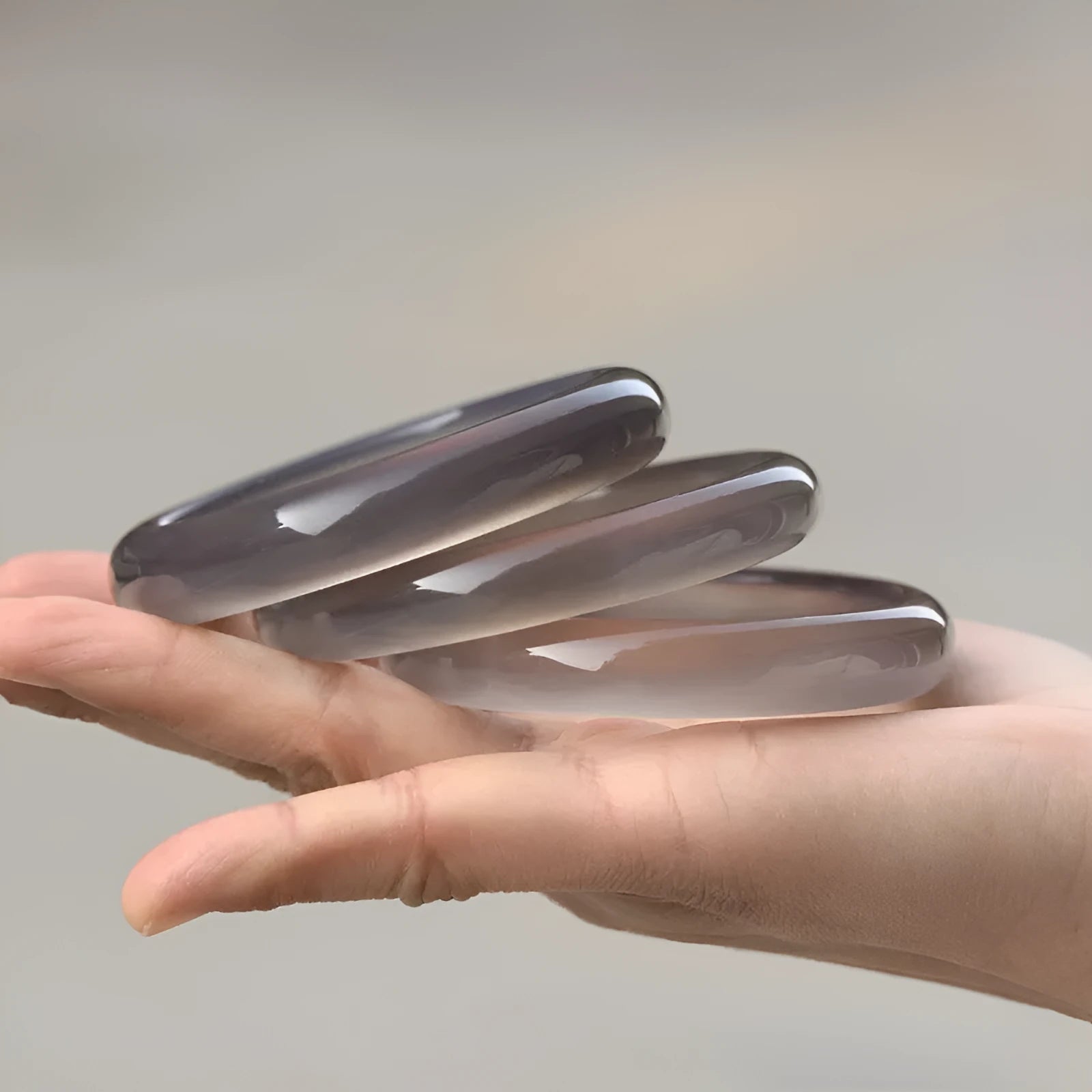 Dark grey Brazilian iced chalcedony agate bracelet with circle beads on a wrist, showing six size options.