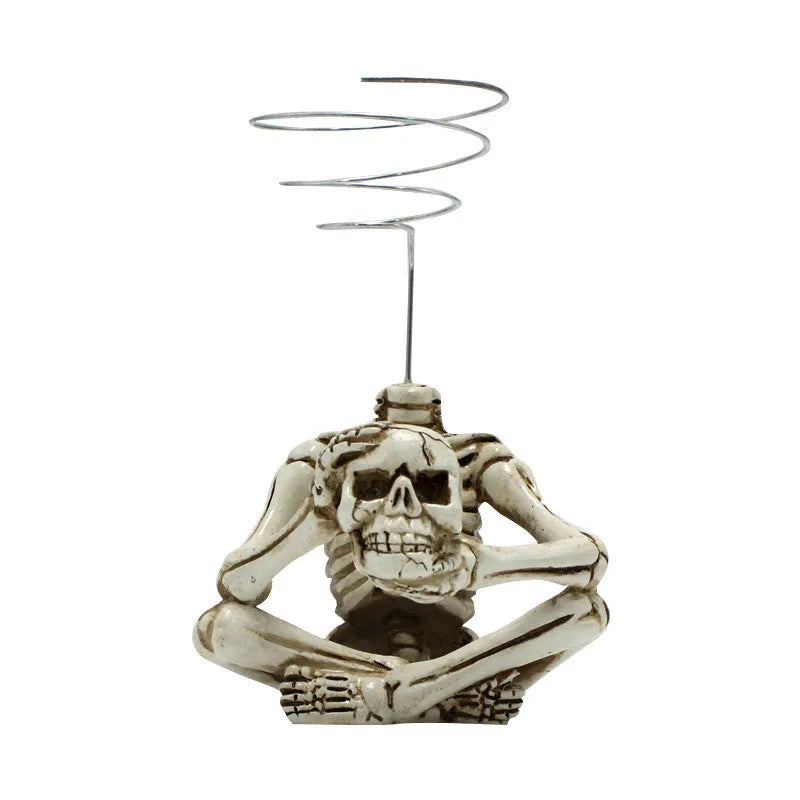Gothic skull-shaped resin bracket for Tillandsia air plants on a wall.