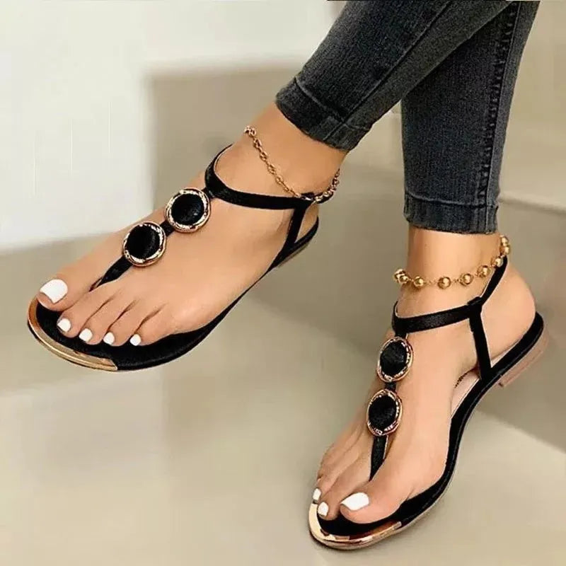 Women's flat sandals with metal buckle detail and round toe in black artificial PU upper