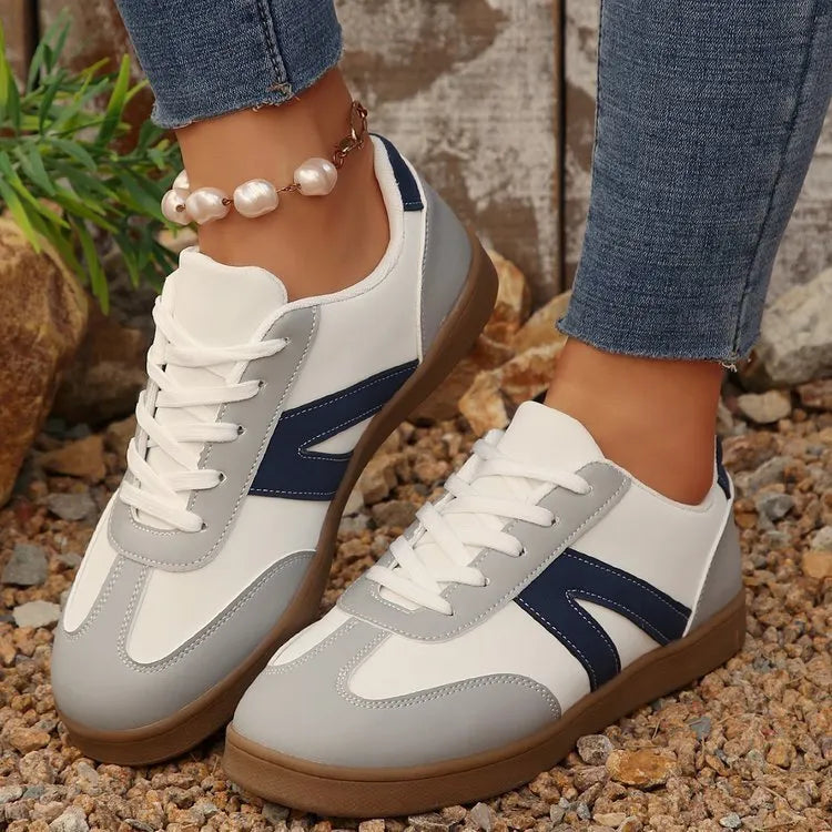 Blue women's low-top hiking shoes with rubber sole and lace-up design on an outdoor background.