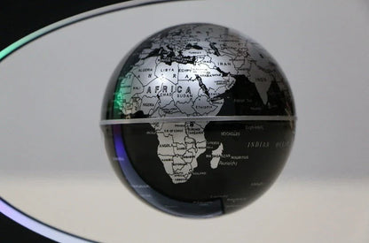 Magnetic levitation globe floating above base with LED light on
