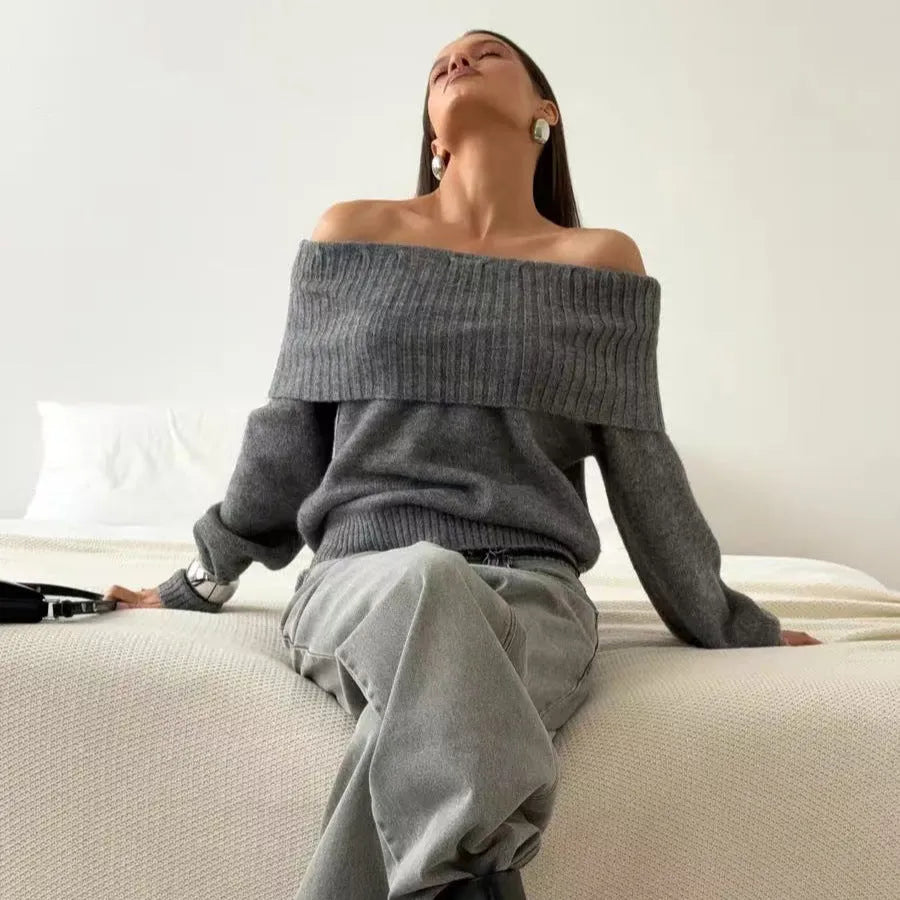 Grey off-the-shoulder acrylic sweater with a textured 3D pattern on a hanger.