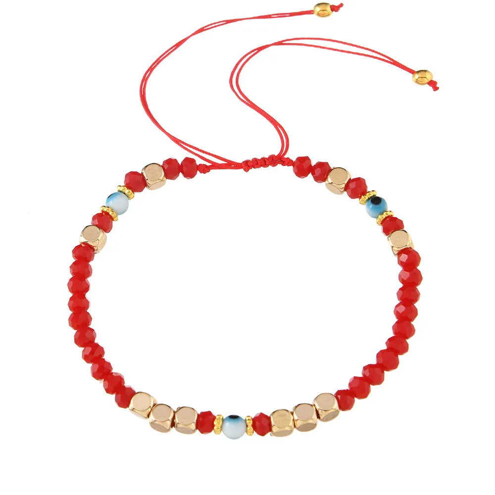 Red hand-woven beaded couple bracelet with artificial crystal eye geometric design on white background