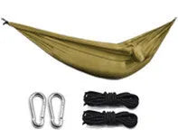 Ultralight outdoor camping nylon hammock in black grey colour, unfolded on grass with trees in background