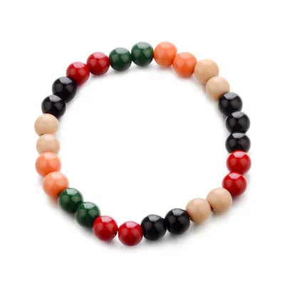 Natural stone beaded bracelet with a lava stone charm for essential oils on a wrist.