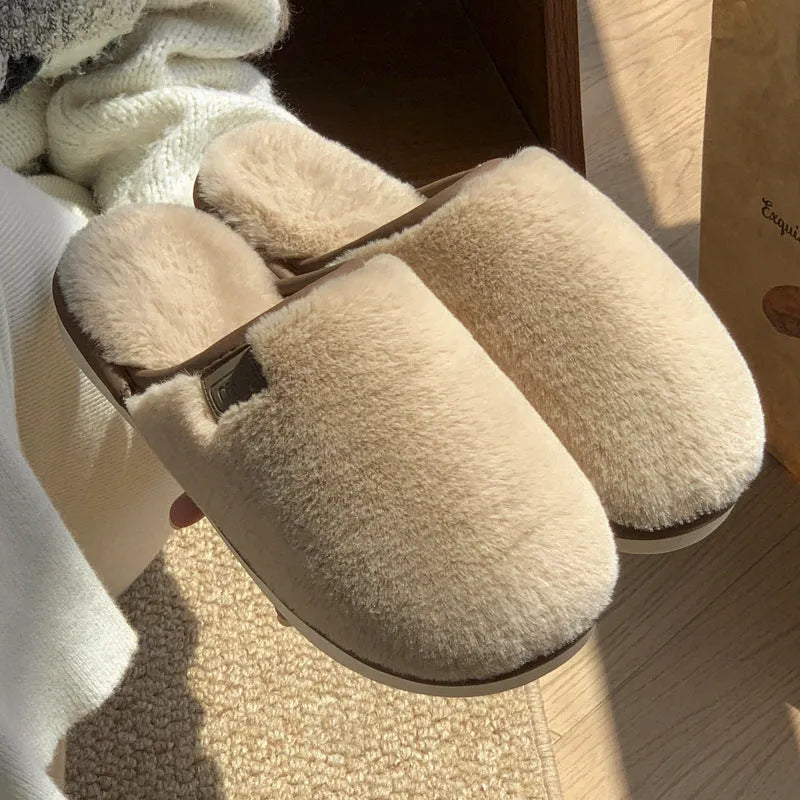 Blue plush slipper with non-slip PVC sole and car-stitching detail on a wooden floor.