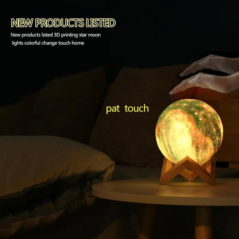 3D printed white lunar sphere night light glowing with soft yellow light on a dark surface.