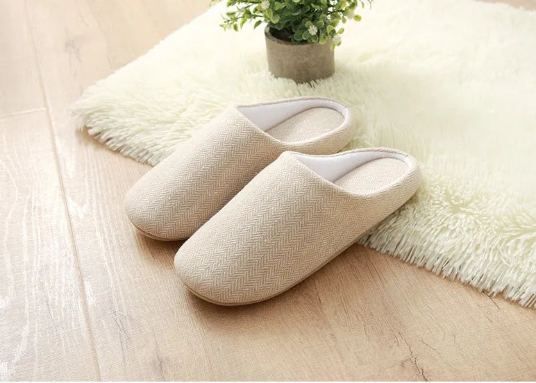 Men's black cotton indoor slippers with soft anti-skid sole on a wooden floor