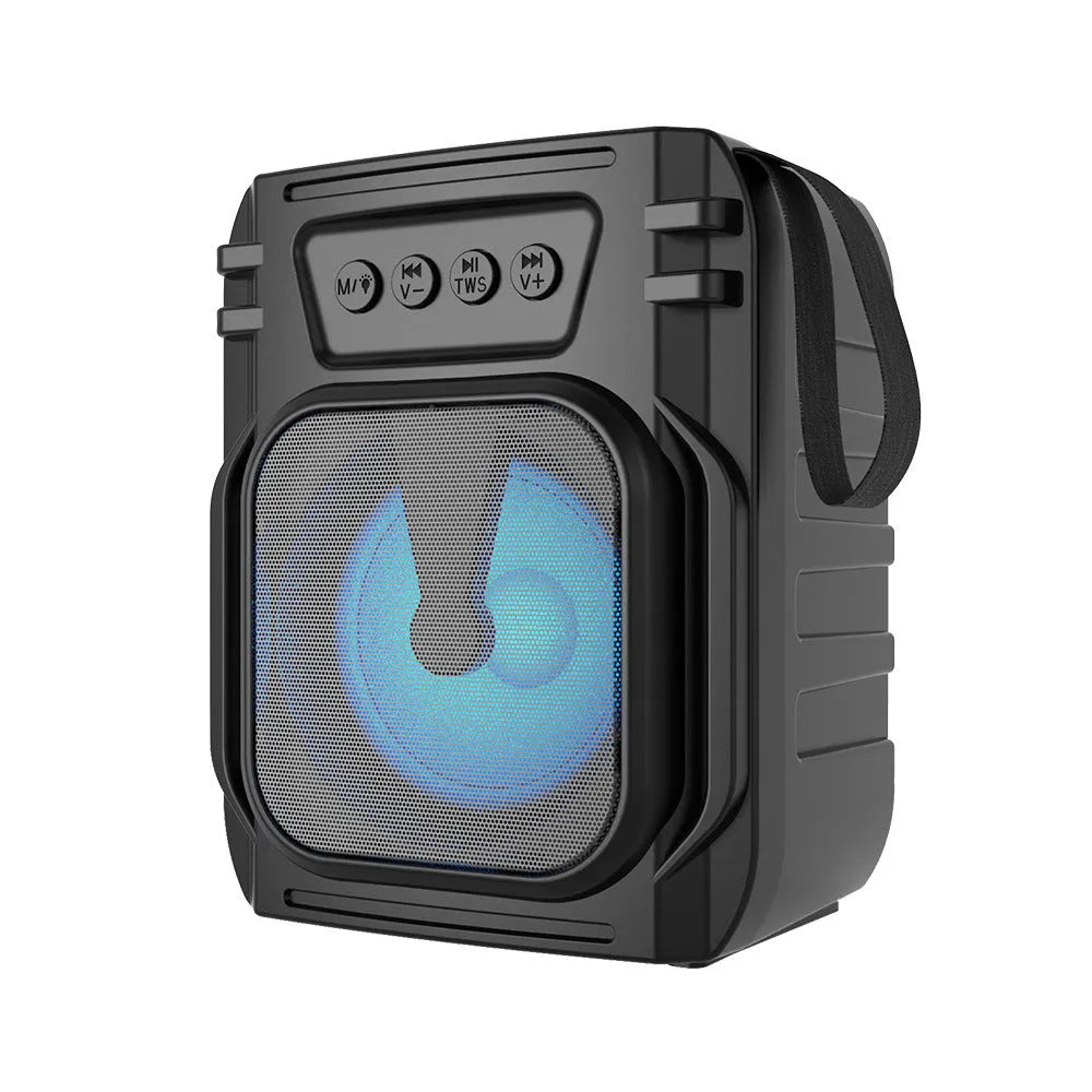Compact portable Bluetooth speaker with USB charging cable on a desk.