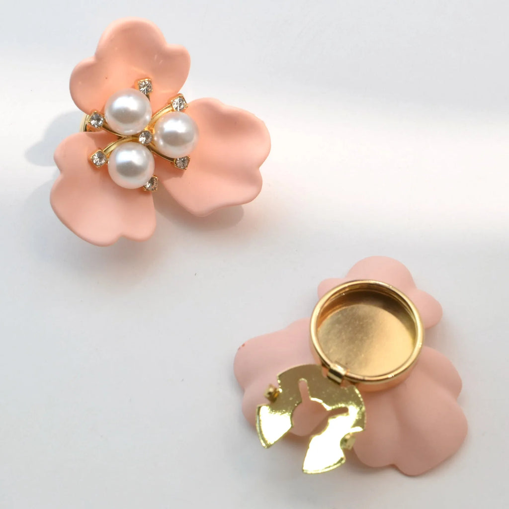 Metal cufflinks with pearl three-flap design in gold, pink, red, and white colours on white background