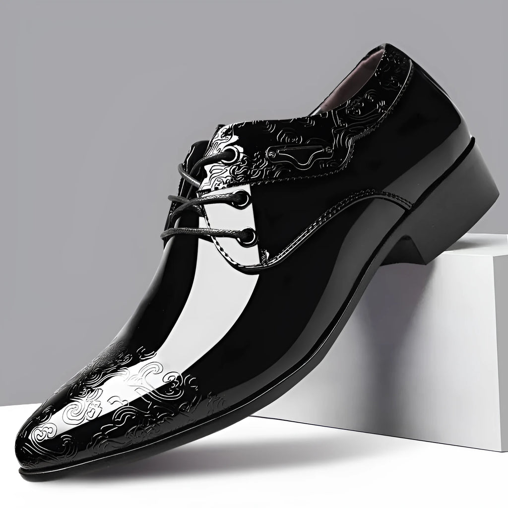 Glossy black men's formal shoes with pointed toe, low top, and carved detail on microfiber leather upper
