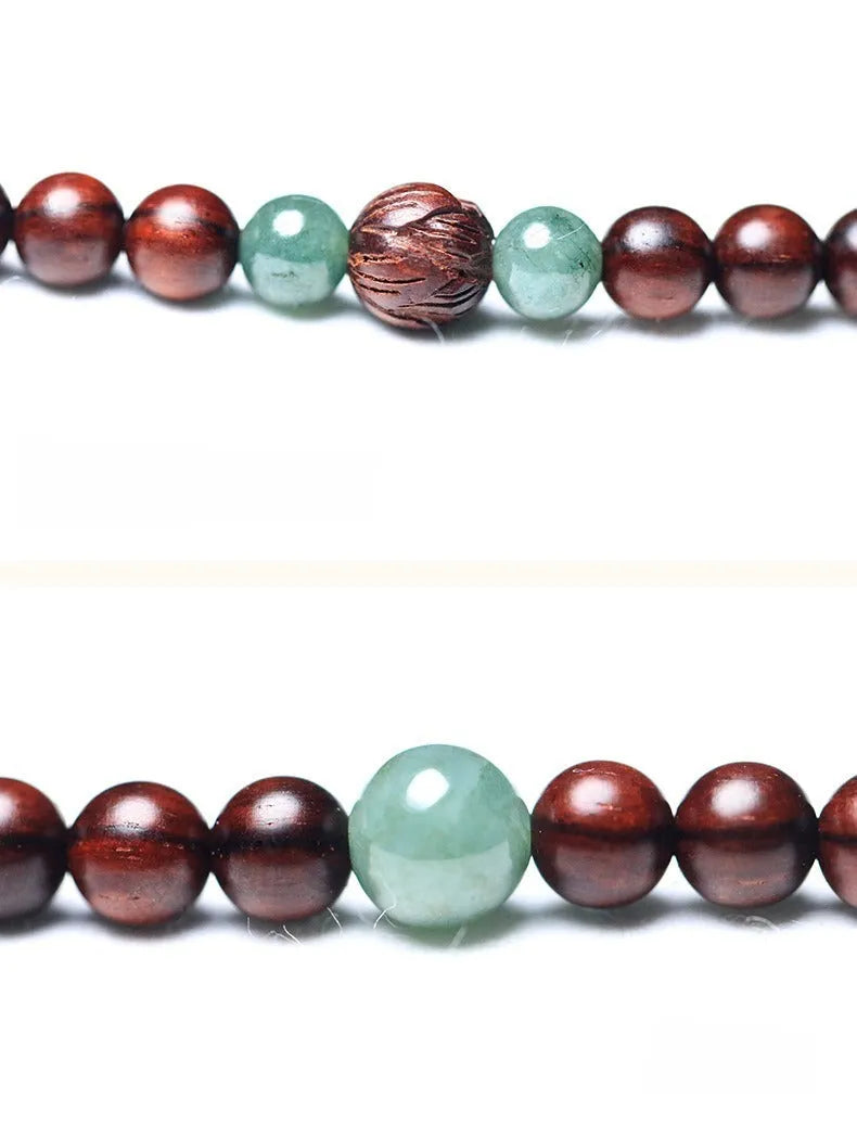 Close-up of a rosewood bead bracelet with 108 beads and a carved Hotian jade pendant.