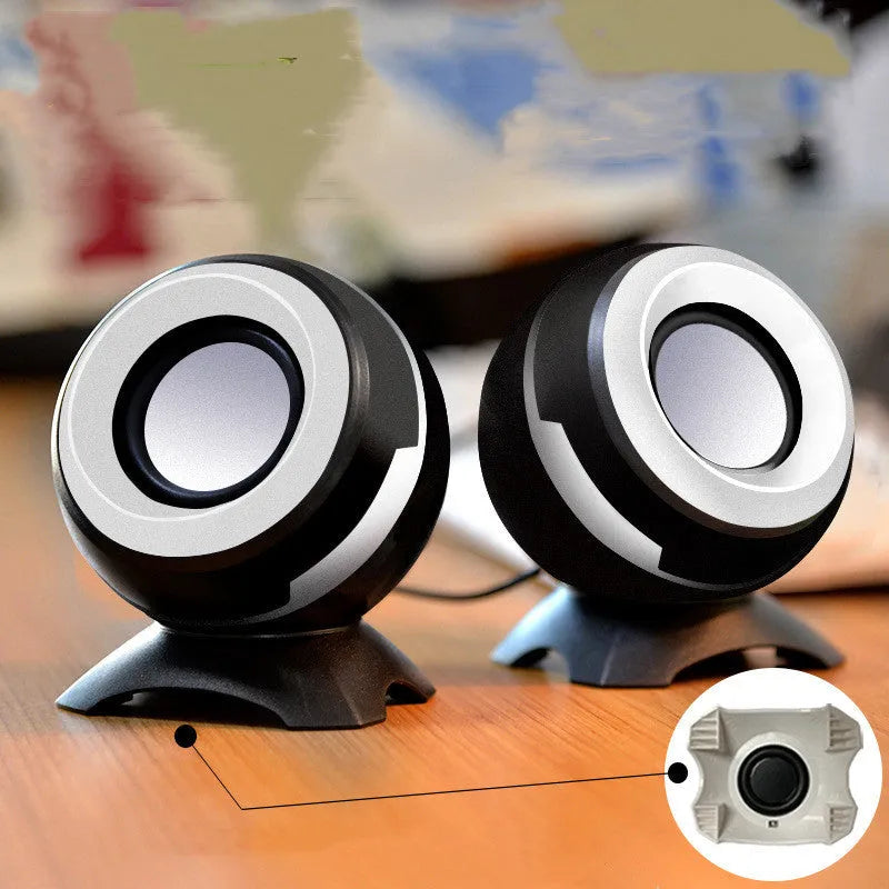 Compact black and gold USB-powered stereo desktop speakers next to a laptop.
