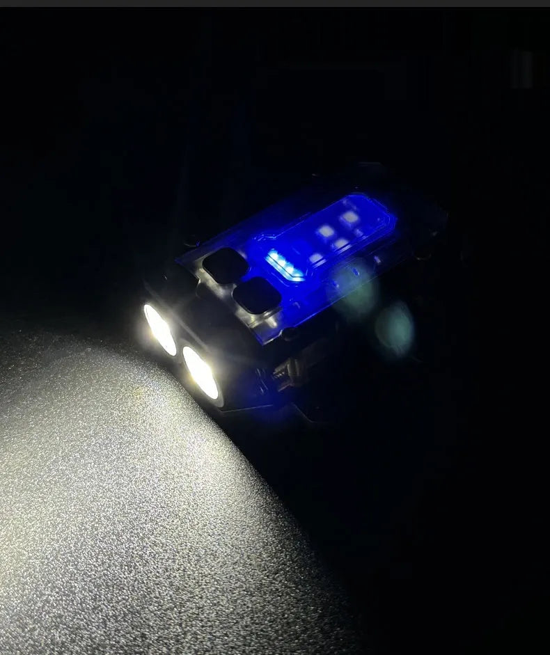 Black portable tactical mini warning flashlight with USB charging cable on a backpack strap.