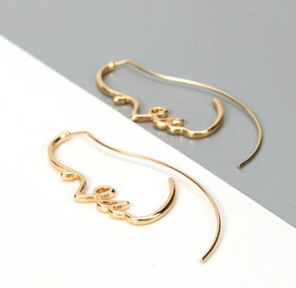 Abstract face contour earrings in gold and silver, 75mm x 35mm