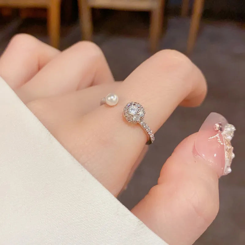 Open-end pearl ring with round zircon stone in gold or silver colour, showing geometric shape and thick real gold plating.
