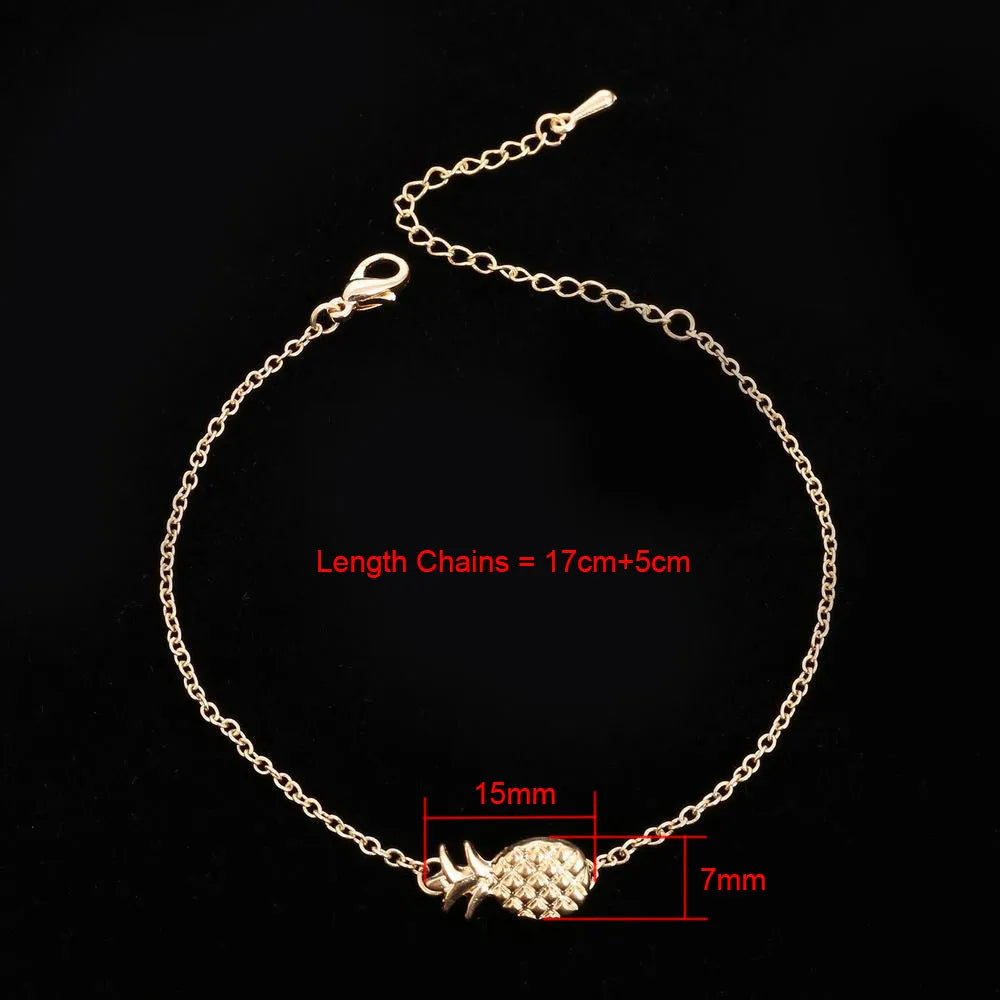 Women's alloy pineapple charm bracelet in gold or silver colour on a wrist.