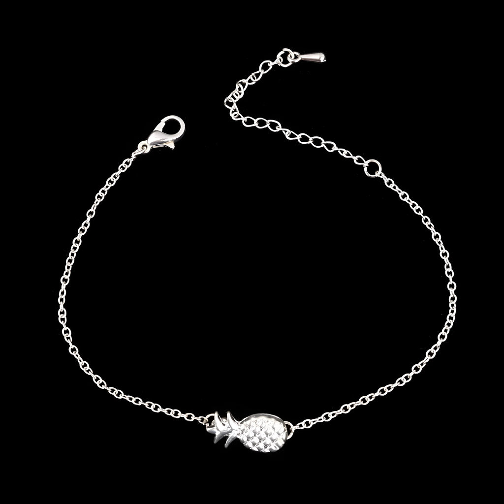 Women's alloy pineapple charm bracelet in gold or silver colour on a wrist.